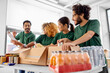 © Syda Productions - charity, donation and volunteering concept - international group of happy smiling volunteers packing food in boxes according to list on clipboard at distribution or refugee assistance center