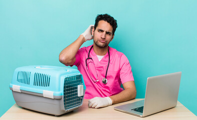 Poster - hispanic handsome man smiling happily and daydreaming or doubting. veterinarian concept