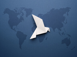 Wall Mural - White origami pigeon on a blue paper background, world peace concept