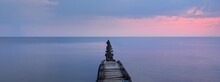 Panoramic View From The Baltic Sea Shore After The Storm. Dramatic Sky, Glowing Pink Sunset Clouds. Old Wooden Pier (jetty). Nature, Environment, Ecology, Climate Change, Fickle Weather