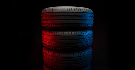 Wall Mural - New car tires. Group of road wheels on dark background. Summer Tires with asymmetric tread design. Driving car concept.