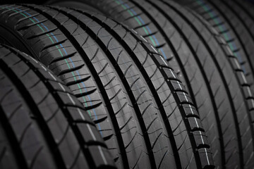  New car tires. Group of road wheels on dark background. Summer Tires with asymmetric tread design. Driving car concept. Close-up