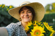 © Анастасія Стягайло - Beautiful young woman with sunflowers enjoying nature and laughing on summer sunflower field. Woman holding sunflowers. Sunflare, sunbeams, glow sun, freedom and happiness concept.