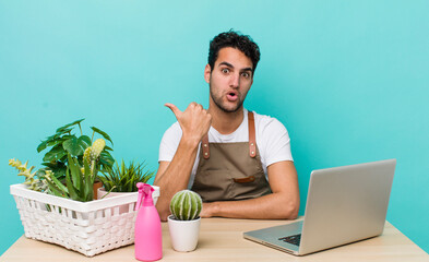 Wall Mural - hispanic handsome man looking astonished in disbelief. garden and plants concept