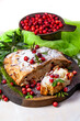 Delicious cranberry pie with fresh cranberries and herbs for Christmas on wooden plate