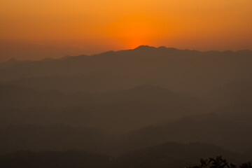 Wall Mural - Sunset mountains. Background with orange sky and mountains