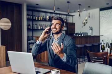 A businessman talking on the phone in a cafe.