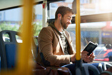 Checking Out The Best Tourist Spots. Cropped Shot Of A Handsome Young Man Reading A Book During His Morning Bus Commute.