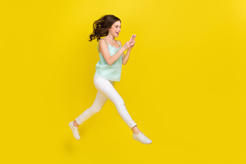 Canvas Print - Full length profile side photo of cute charming casual wear girl surfing social media isolated on yellow color background