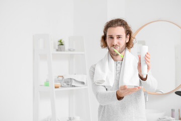 Canvas Print - Handsome young man brushing teeth with paste in bathroom