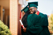 © Drazen - Happy black college student and his female friend hug each other while celebrating their graduation.