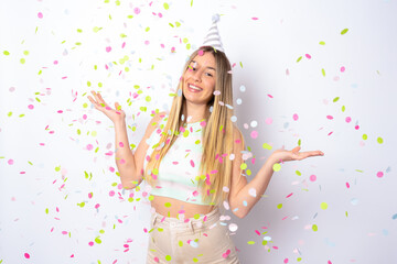 Wall Mural - Portrait of a happy beautiful young woman standing under confetti rain and celebrating isolated over white background