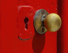 Closeup Shot Of An Old Style Door Handle And Keyhole On A Red A Door In Bright Sunlight