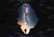 Silhouette of a person in the cave looks on the bright milky way galaxy. Fantasy Scene.