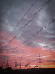 Wall Mural - Power lines and electrical pylons against a cloudy sunset sky