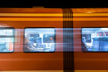 Poster - Guy in a medical mask on a modern orange train passing by