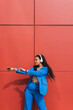© Dani D.G - Dance student, training outdoors, wearing modern stylish blue clothes, with a red wall in the background. Concept of joy, street art, youth and vitality.