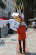 man with hat and sandals carrying many boxes in the city