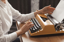 Womans Hands Typing On A Yellow Vintage Mechanical Typewriter