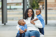 © Ursula Page - A mom with long hair sitting outside with her two young sons