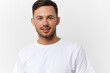 © SHOTPRIME STUDIO - Cheerful cute happy young tanned handsome man in basic t-shirt smile at camera posing isolated on over white studio background. Copy space Banner Mockup. People emotions Lifestyle concept. Portrait