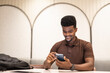 © Ranta Images - Handsome black man at coffee shop using mobile phone