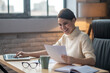 © zinkevych - A woman sitting at the table in the office and working