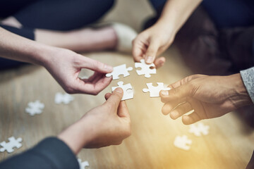 Poster - We fit together. Shot of a group of people building a puzzle together.