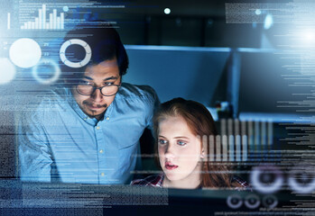 Poster - Teamwork goes a long way in the company. Shot of two focussed young programmers working together on a computer in the office at work during the night.