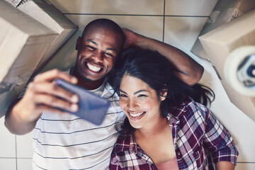 Poster - New memories in their new home. High angle shot of a young couple taking a selfie in their new home.