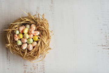 Easter background with Easter eggs in a nest. Top view with copy space. Easter holidays banner and header.