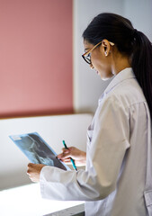 Canvas Print - Your oral health is intrinsically linked to your general health. Cropped shot of a young female dentist analysing an x-ray.