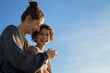 © ideasRojas  - Mother and mixed race adopted daughter enjoying a leisure time and laughing together outdoors at sunset time during summer vacation. Family love concept. Mother's day. Copy space