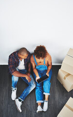 Aufkleber - Looking up decor ideas together. High angle shot of a young couple moving house.