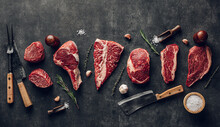 Different Of Pork Or Beef Steaks With Spices And Butcher Fool On Dark Background