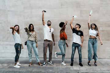 Happy group of friends celebrating the end of coronavirus waving the face masks