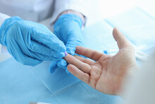Nurse Lab Technician In Gloves, Using Painless Scarifier To Prick Finger Of Patient