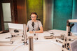 © Daria Lukoiko - The DJ hosts the program and communicates with the audience on air at the radio station. The announcer reads the news. A male radio host speaks into a microphone and records a podcast