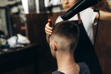 It Already Looks Good. Close Up View From The Back Of A Young Man Caring With Hairdresser With Hairdryer In Barbershop