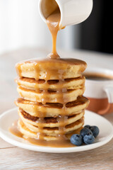 Wall Mural - Caramel sauce pouring on pancakes. Stack of pancakes with caramel. Sweet breakfast food