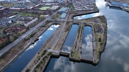 Wall Mural - Aerial image over the River Clyde towards Govan in Glasgow, Scotland. A bright sunny day with sky reflections in unused docks giving appearance of huge arched windows like a cathedral.