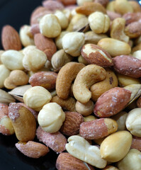 Wall Mural - a bowl full of roasted hazelnuts, pistachios, cashews and a plate of various nuts,