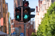Traffic Semaphore With Green Light And Green Figure Of Pedestrian On Defocused City Street