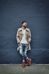 Canvas Print - Style thats hot off the street. Shot of a fashionable young man wearing urban wear and posing against a gray wall.