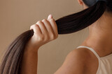 Fototapeta  - Young woman hand holding ponytail in studio