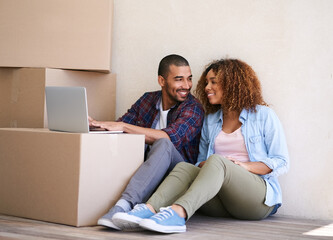 Aufkleber - Changing their status from for sale to sold. Shot of a young couple using a laptop while sitting among boxes on moving day.