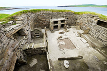 Skara Brae Stone Age Neolithic Village At Skaill, Orkney, Scotland. Interior, Box Beds, Hearth And Dresser 3100 BC. House 1 With Bay Of Skaill Behind