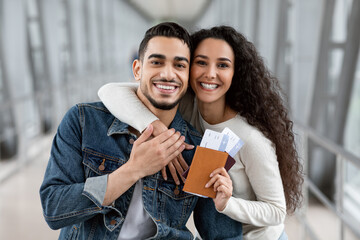 Wall Mural - Joyful Millennial Arab Spouses With Passports And Tickets In Hands At Airport