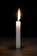 © Zuev Ali - A wax candle burns in the dark.