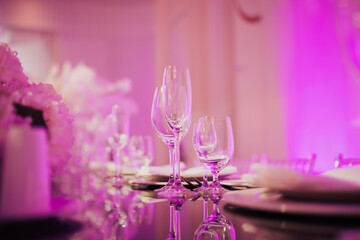 Wall Mural - Table setting for an event party or wedding reception in the luxury restaurant in purple light.